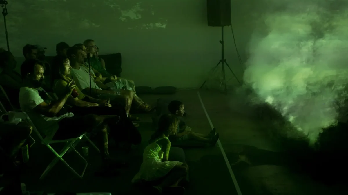Audience bathed in green light and haze during Per Aria at ESPRONCEDA