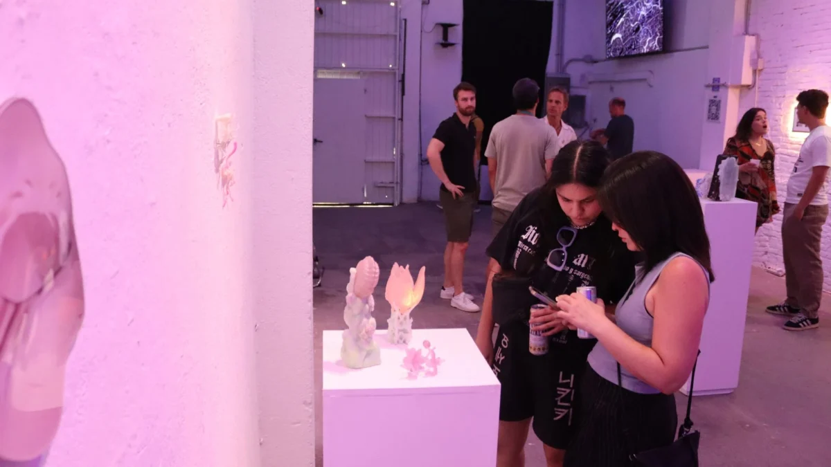 Visitors observing translucent sculptures at the Spinning in Fluid Dreams opening